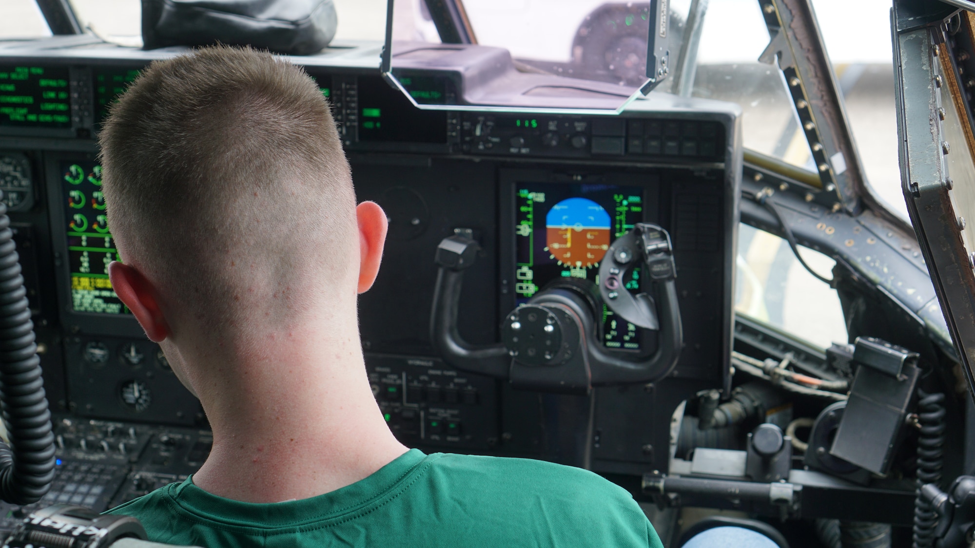 A Junior ROTC cadet sits in the co-pilot seat of a C-130J Super Hercules aircraft.