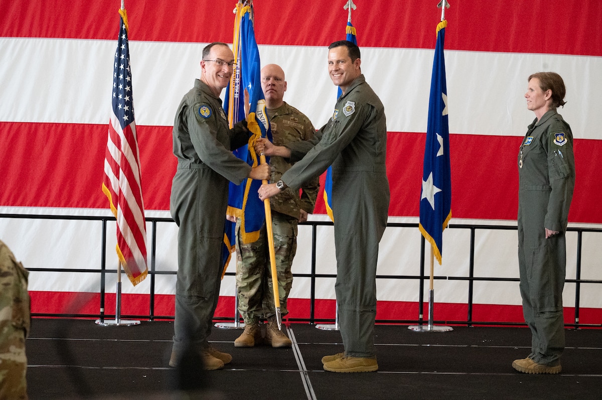 Lt. Gen. John P. Healy, Chief of Air Force Reserve and Commander, Air Force Reserve Command, passes the 10th Air Force guidon to Brig. Gen. Kevin Merrill, symbolizing Merrill’s official assumption of command. Standing ready to continue the tradition, Chief Master Sgt. Jeremy Allen prepares to receive the guidon as the incoming Command Chief of 10th Air Force.