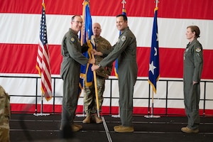 Lt. Gen. John P. Healy, Chief of Air Force Reserve and Commander, Air Force Reserve Command, passes the 10th Air Force guidon to Brig. Gen. Kevin Merrill, symbolizing Merrill’s official assumption of command. Standing ready to continue the tradition, Chief Master Sgt. Jeremy Allen prepares to receive the guidon as the incoming Command Chief of 10th Air Force.