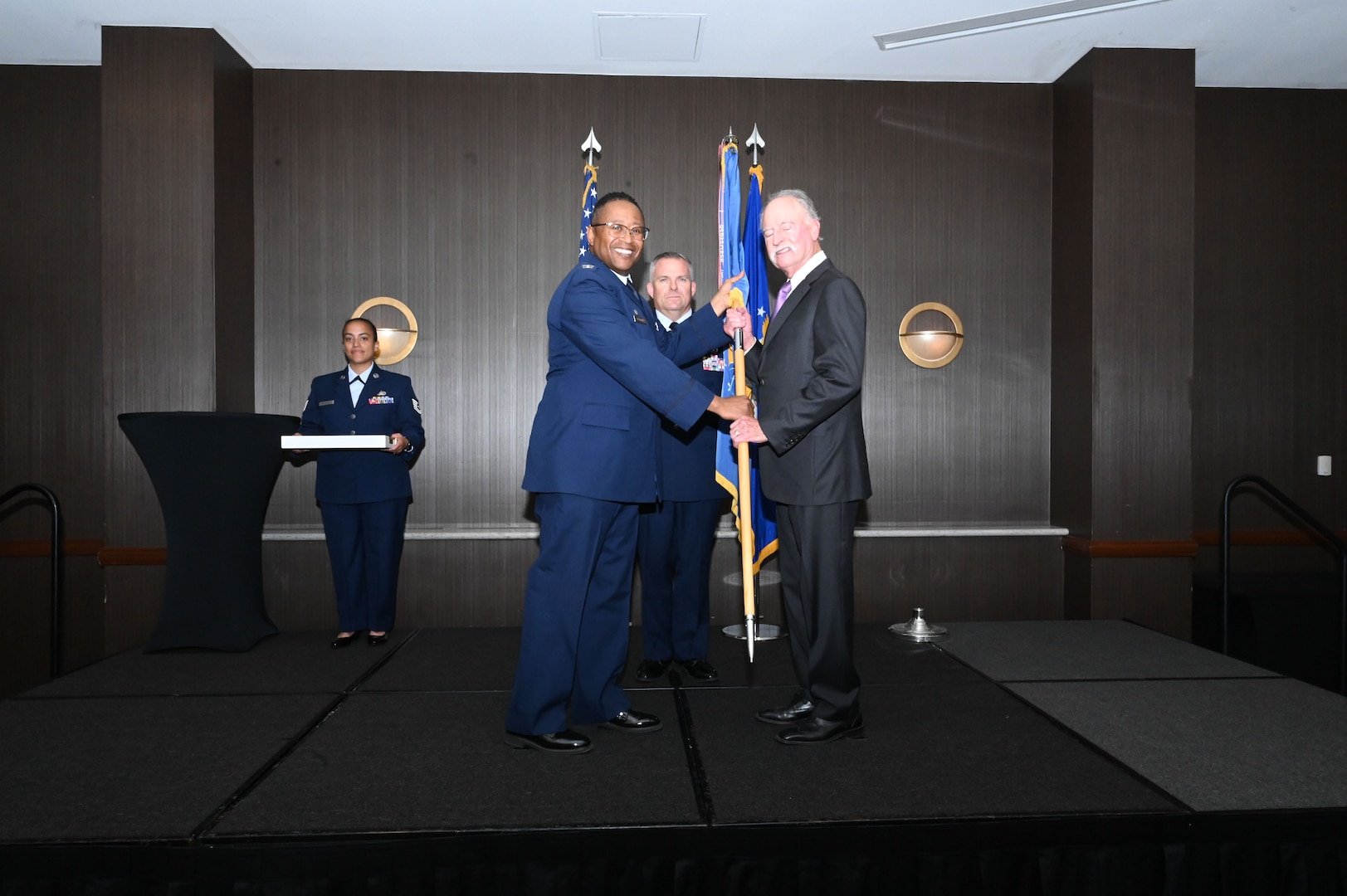 Col. Alvin Bradford, 433rd Medical Squadron commander, hands the 433rd Airlift Wing guidon to Mike Kurczek, retired critical care anesthesiologist, during the 433rd AW 2025 Honorary Commanders’ Induction Ceremony in San Antonio, June 7, 2025.