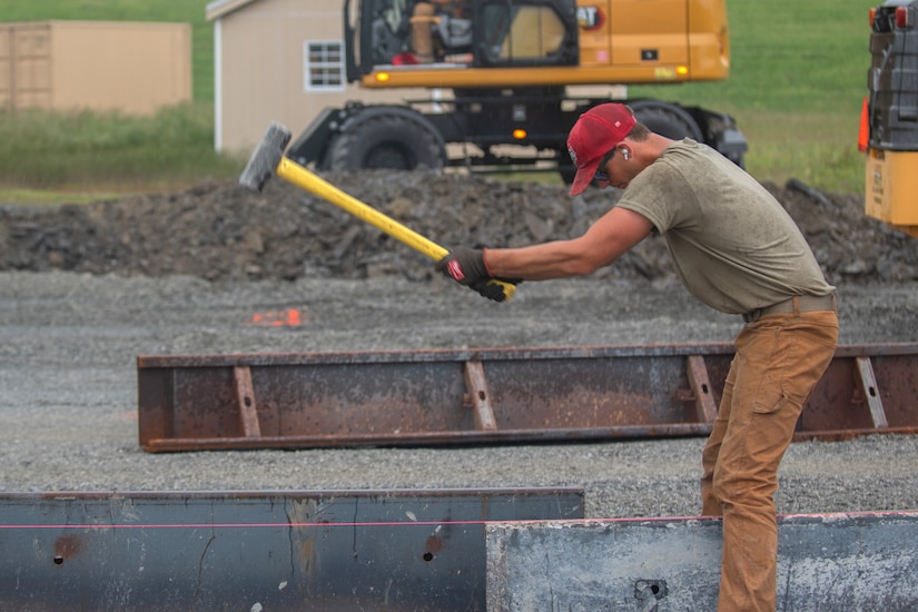 Airman 1st Class Nicholas Vallario, pavements and construction equipment specialist with the 201st RED HORSE Detachment 1, constructs a Rapid Airfield Damage Repair system at Fort Indiantown Gap, Pennsylvania, June 6, 2025. This mock runway will be used as a training asset for the Air National Guard Schoolhouse, operated by the 193rd Special Operations Wing, to help civil engineering Airmen learn how to quickly repair an airfield in combat situations. (U.S. Air Force photo by Airman Austin Stern)