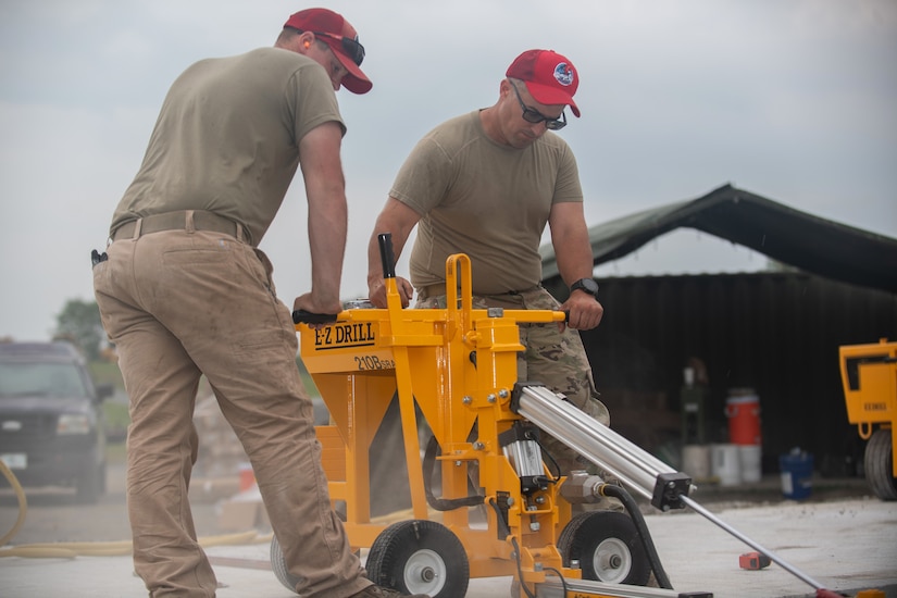 Tech Sgt. William Leinbach, assigned to the 201st RED HORSE, drills concrete at Fort Indiantown Gap, Pennsylvania, June 7, 2025. Leinbach drilled to connect concrete slabs and prevent upheaval. (U.S. Air Force photo by Airman Austin Stern)
