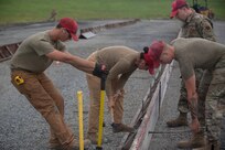 Airman from various civil engineering specialties construct a Rapid Airfield Damage Repair system at Fort Indiantown Gap, Pennsylvania, June 6, 2025. The mock runway will be used as a training asset for the Air National Guard Schoolhouse, operated by the 193rd Special Operations Wing, to help civil engineering Airmen learn how to rapidly repair an airfield in combat situations. (U.S. Air Force photo by Airman Austin Stern)
