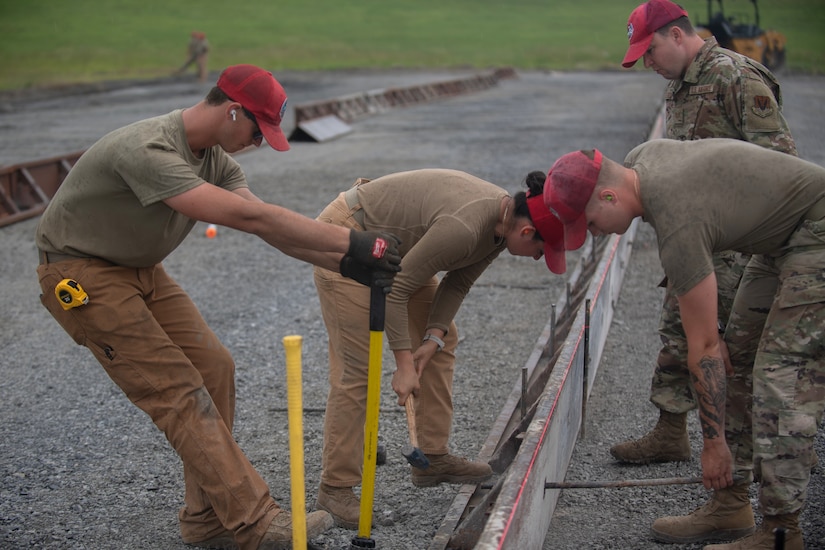 Airman from various civil engineering specialties construct a Rapid Airfield Damage Repair system at Fort Indiantown Gap, Pennsylvania, June 6, 2025. The mock runway will be used as a training asset for the Air National Guard Schoolhouse, operated by the 193rd Special Operations Wing, to help civil engineering Airmen learn how to rapidly repair an airfield in combat situations. (U.S. Air Force photo by Airman Austin Stern)