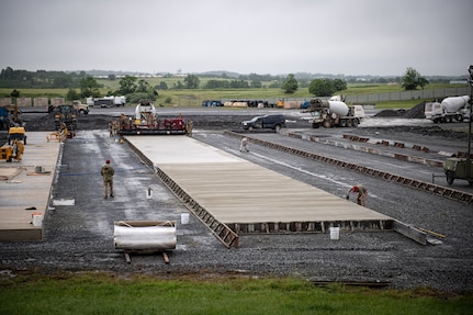 Airmen from various civil engineering specialties construct a Rapid Airfield Damage Repair system at Fort Indiantown Gap, Pennsylvania, June 9, 2025. The mock runway will be used as a training asset for the Air National Guard Schoolhouse, operated by the 193rd Special Operations Wing, to help civil engineering Airmen learn how to rapidly repair an airfield in combat situations. (U.S. Air National Guard photo by Tech. Sgt. Tony Harp)
