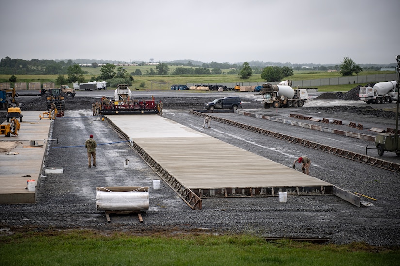 Airmen from various civil engineering specialties construct a Rapid Airfield Damage Repair system at Fort Indiantown Gap, Pennsylvania, June 9, 2025. The mock runway will be used as a training asset for the Air National Guard Schoolhouse, operated by the 193rd Special Operations Wing, to help civil engineering Airmen learn how to rapidly repair an airfield in combat situations. (U.S. Air National Guard photo by Tech. Sgt. Tony Harp)