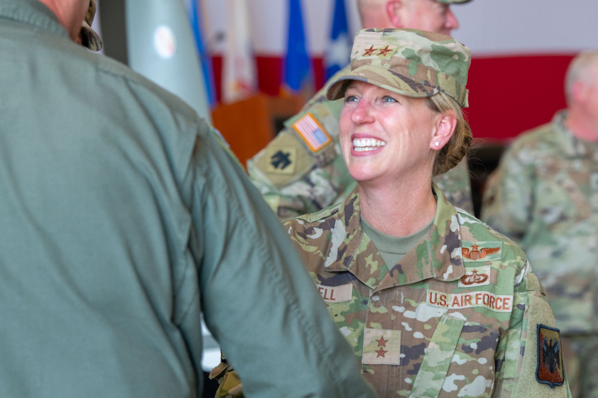 A woman shakes hands with another military member