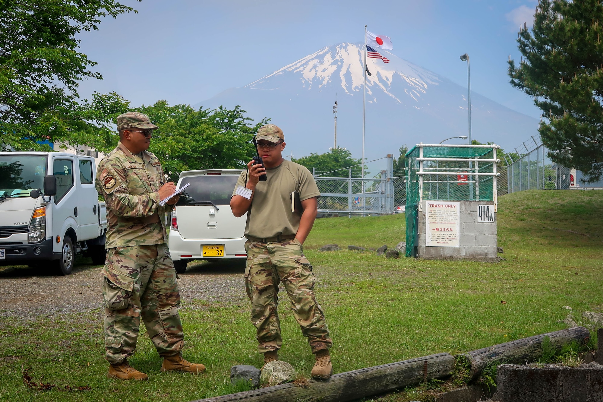 Airman speaks through radio while other Airman speaks.