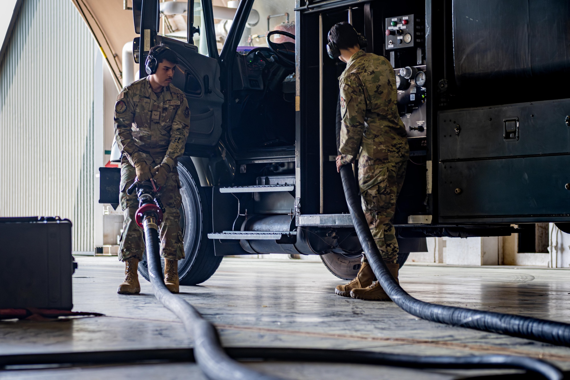 U.S. Air Force Senior Airman Jose Pro, left, and U.S. Air Force Airman 1st Class Andrews Mikel, 35th Logistic Readiness Squadron fuels distribution operators, round up the hose for an R-11 fueling truck at Misawa Air Base, June 10, 2025.