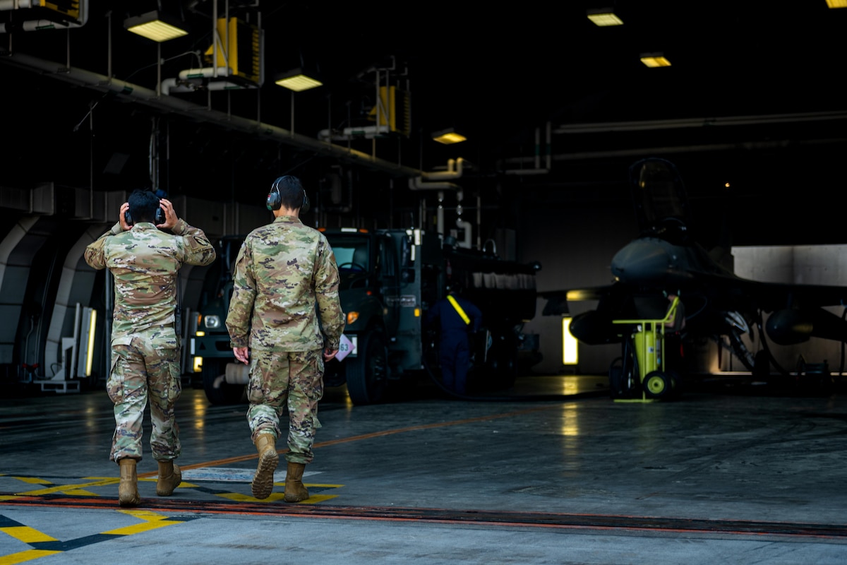 U.S. Air Force Senior Airman Jose Pro, left, and U.S. Air Force Airman 1st Class Andrews Mikel, 35th Logistic Readiness Squadron fuels distribution operators, approach an R-11 fueling truck and F-16 Fighting Falcon for a fuel run at Misawa Air Base, June 10, 2025.