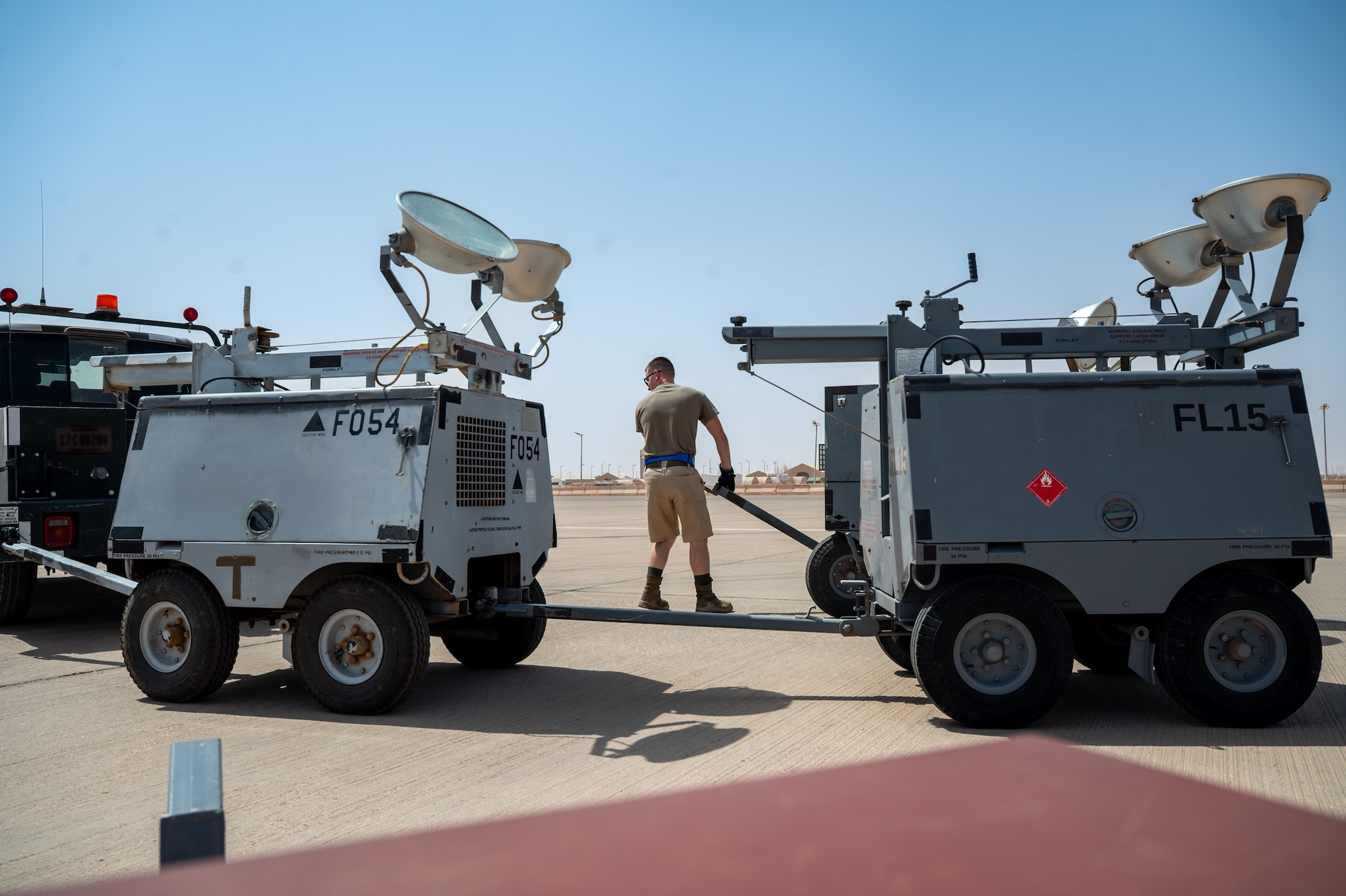 Airman pulls a flood light across the flightline