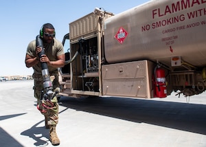 U.S. Airman 1st Class Jason King, 379th Expeditionary Logistics Readiness Squadron fuels operator, carries an R-11 fuel truck hose within the U.S. Central Command area of responsibility, June 5, 2025. The 379th ELRS petroleum, oil and lubricant flight is a vital part of the 379th Air Expeditionary Wing's mission, ensuring the availability of fuel and maintaining the readiness of the fleet. (U.S. Air Force photo by Master Sgt. J.D. Strong II)