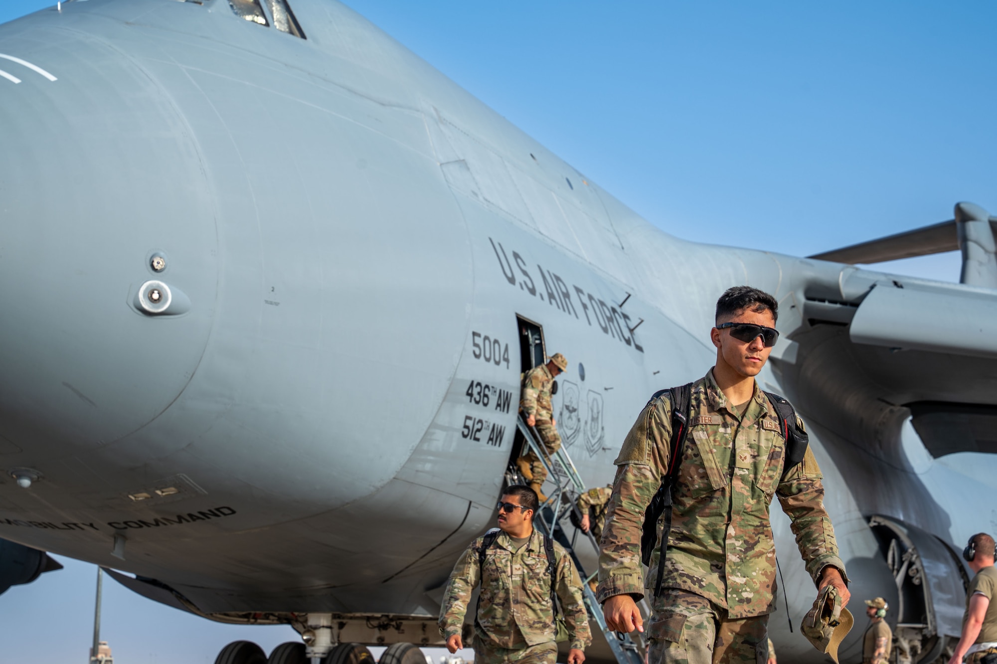 Airmen exit a plane.