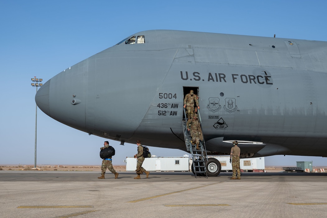 Airmen exit a plane.