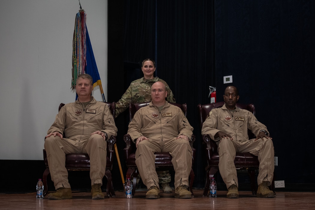 From the left, U.S. Air Force Maj. Gen. David Shoemaker, 9th Air Force (Air Forces Central) deputy commander, Brig. Gen. Richard Dickens, 379th Air Expeditionary Wing outgoing commander, and Brig. Gen. Travis Edwards, incoming 379th AEW commander, sit during the 379th AEW Change of Command Ceremony within the U.S. Central Command area of responsibility, June 9, 2025. The ceremony saw Dickens relinquish command to Edwards. (U.S. Air Force photo by Staff Sgt. Sean Moriarty