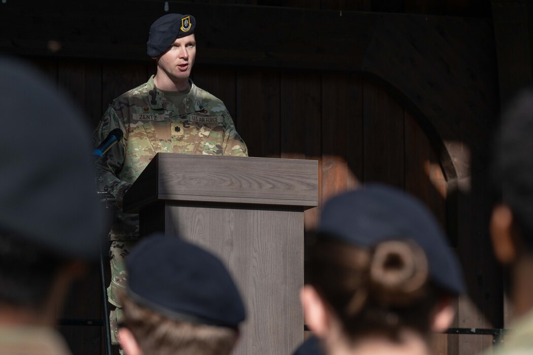 An Airman delivers remarks to a crowd of more Airmen from behind a podium.