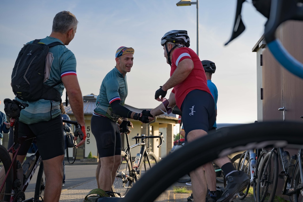 Two cyclists shake hands in greeting before beginning the Eifel to Eiffel bike ride.