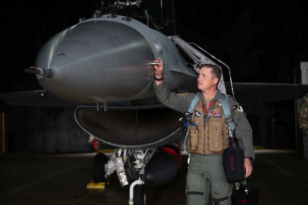 A pilot walks around his jet during a pre-flight inspection.