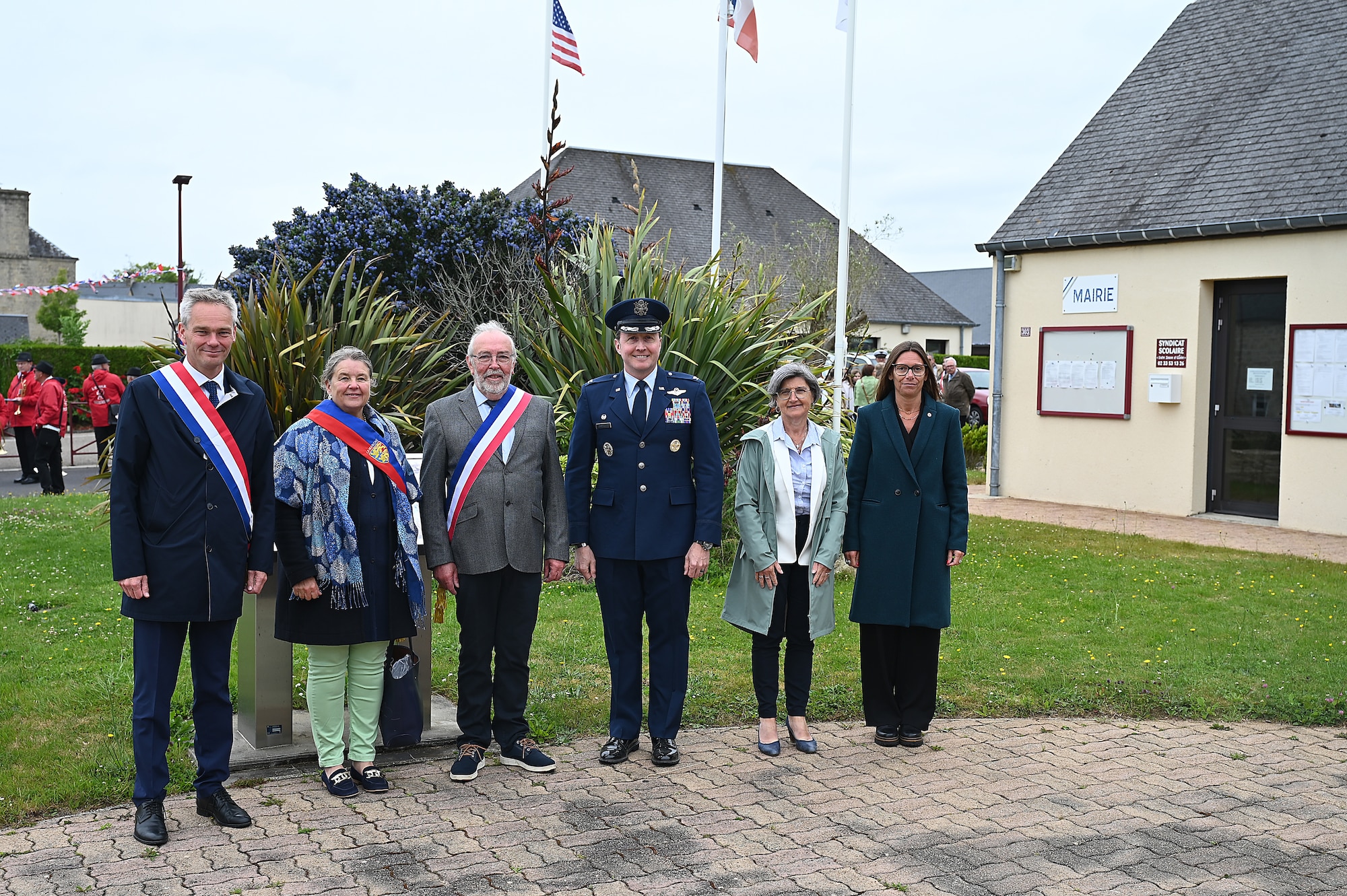 Col. Matthew Bartlett, 435th Air Ground Operations Wing commander (center) poses for a photo with French government officials and local community members before providing a speech during a ceremony highlighted the sacrifices of the crew and paratroopers of a C-47 Skytrain that crashed during D-Day, June 3, 2025. Bartlett, whose wing consists of over 1,400 personnel across 11 installations in Europe and the U.S., emphasized the importance of connecting with the courage and sacrifice of the D-Day generation. (Photo by Capt Lou Burton, 435th AGOW Public Affairs)