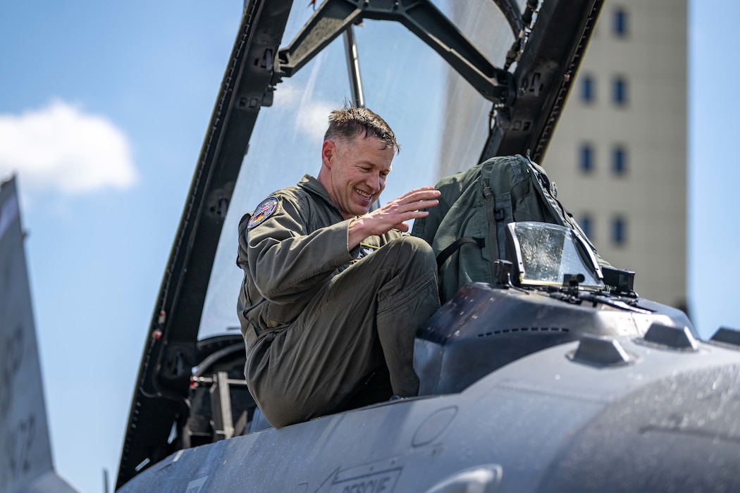A pilot prepares to climb down from the cockpit of his fighter aircraft.