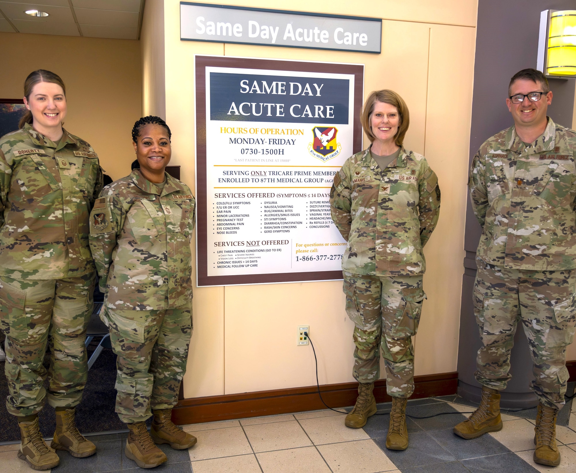 U.S. Air Force Col. Ann McManis, 87th Medical Group commander (2nd from right), stands with members of the 87th MDG team by the Same Day Acute Care clinic sign at Joint Base McGuire-Dix-Lakehurst, N.J., April 28, 2025. Designed for non-life-threatening acute conditions, the Same Day Acute Care clinic addresses ailments such as colds, flu, sore throats, and minor injuries, and offers a walk-in, on-demand service with no appointment necessary. (U.S. Air Force photo by Susan Moriarty)