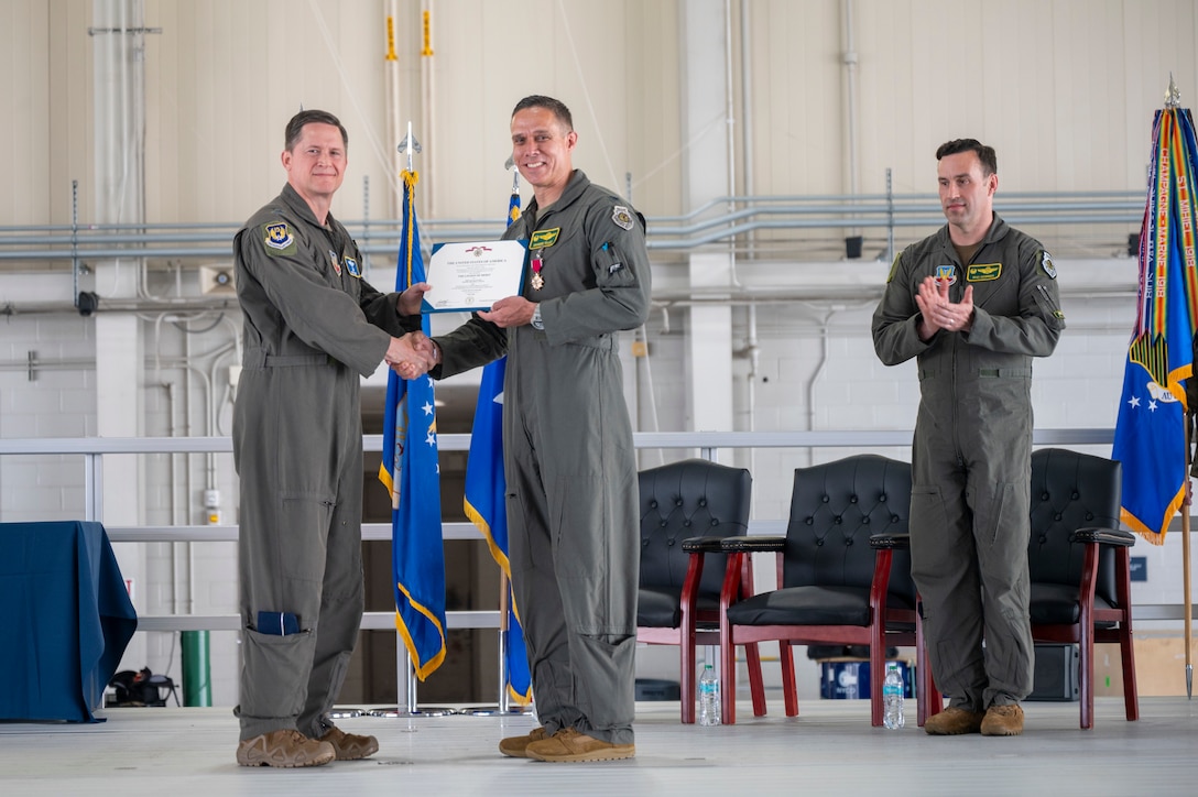 U.S. Air Force Maj. Gen. David Lyons, 15th Air Force commander presents Col. Brandon “Gringo” Tellez, outgoing 1st Fighter Wing commander, with the Legion of Merit during a change of command ceremony at the 71st Fighter Squadron, Langley Air Force Base, June 6, 2025. Throughout his command, Tellez drove the wing to achieve new levels of combat success such as setting historic Air Force records in F-22 sortie production, reviving William Tell and the Mitchell Trophy Air Race. (U.S. Air Force Tech. Sgt. Matthew Coleman-Foster)