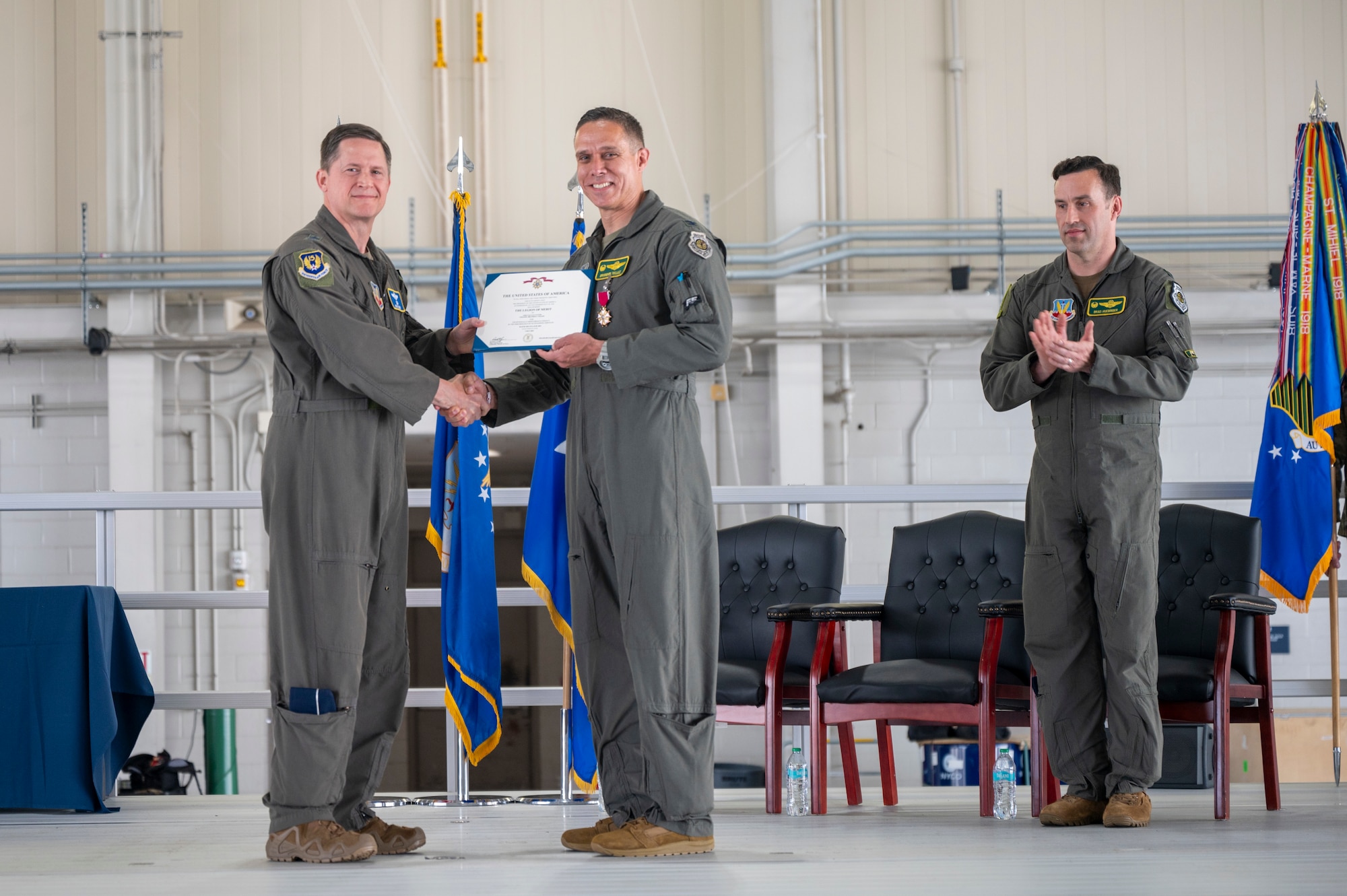 U.S. Air Force Maj. Gen. David Lyons, 15th Air Force commander presents Col. Brandon “Gringo” Tellez, outgoing 1st Fighter Wing commander, with the Legion of Merit during a change of command ceremony at the 71st Fighter Squadron, Langley Air Force Base, June 6, 2025. Throughout his command, Tellez drove the wing to achieve new levels of combat success such as setting historic Air Force records in F-22 sortie production, reviving William Tell and the Mitchell Trophy Air Race. (U.S. Air Force Tech. Sgt. Matthew Coleman-Foster)