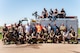 A group of people pose on the side of a firetruck