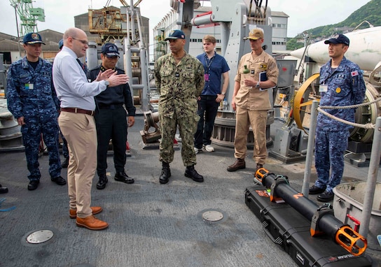 Christian Weber, the Integrated Battle Problem (IBP) 25.5 technology lead from Naval Surface Warfare Center Panama City Division, describes the capabilities of the Hangman underwater system to Japan Maritime Self-Defense Force Rear Adm. Yatsutaka Ebata, commander, Escort Flotilla 2, and Capt. Antonio Hyde, commodore, Mine Countermeasures Squadron 7, during the IBP 25.5 technology demonstration aboard the Avenger-class mine countermeasures ship USS Warrior (MCM 10), at Commander, Fleet Activities Sasebo, Japan, May 15, 2025. Exercises such as Integrated Battle Problem allow the Navy to demonstrate unmanned system operations in relevant experiment scenarios to meet service level objectives and operationalize unmanned systems and capabilities to maintain a secure and prosperous Indo-Pacific region. U.S. 7th Fleet, the U.S. Navy’s largest forward-deployed numbered fleet, routinely interacts and operates with allies and partners in preserving a free and open Indo-Pacific region. (U.S. Navy photo by Mass Communication Specialist 1st Class W. Chase Stephens. Portions of this photo have been obscured for security purposes.)