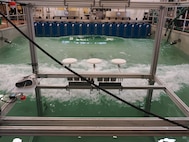 U.S. Naval Research Laboratory (NRL)-National Research Council (NRC) Postdoctoral Fellow with NRL’s Chemistry Division, Center for Corrosion Science and Engineering, Alex Johnson, next to symmetric airfoils used for measuring dry deposition of chloride and sulfate. This is used to study the impact of corrosion from saltwater aerosols at the NRL Laboratory for Autonomous Systems Research (LASR) Littoral Bay Wave Pool, in Washington, D.C., Sept. 24, 2024.