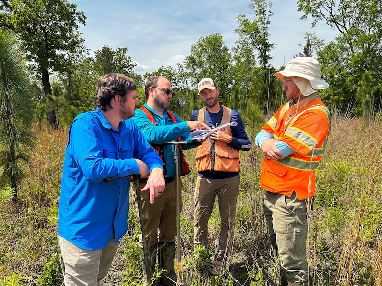 Charleston District project managers along with Ecosystem Planning and Restoration (EPR) member review the delineation line at Brosnan Forest.