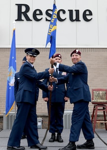 Col. Sean Garell, left, commander of the 106th Operations Group and U.S. Air Force Lt. Col. Marty Viera, right, incoming commander of the 103rd Rescue Squadron, hold the squadron guidon during the change of command ceremony at Francis S. Gabreski Air National Guard Base, Westhampton Beach, N.Y., June 7, 2025.