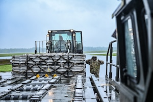 U.S. Air Force Senior Airman Emmanuel Fraiku, right, 87th Aerial Port ramp services representative, guides Tech. Sgt. Benjamin Battista, 87th APS load planning supervisor, as he operates a 25K Halvorson loader to transport a pallet onto a loading dock during the squadron’s semi-annual Port Dawg Challenge at Wright-Patterson Air Force Base, Ohio, May 3, 2025. The APS won the Air Force Reserve Command Logistics Readiness Unit awards for Fiscal Year 2024. (U.S. Air Force photo by Master Sgt. Patrick O’Reilly)