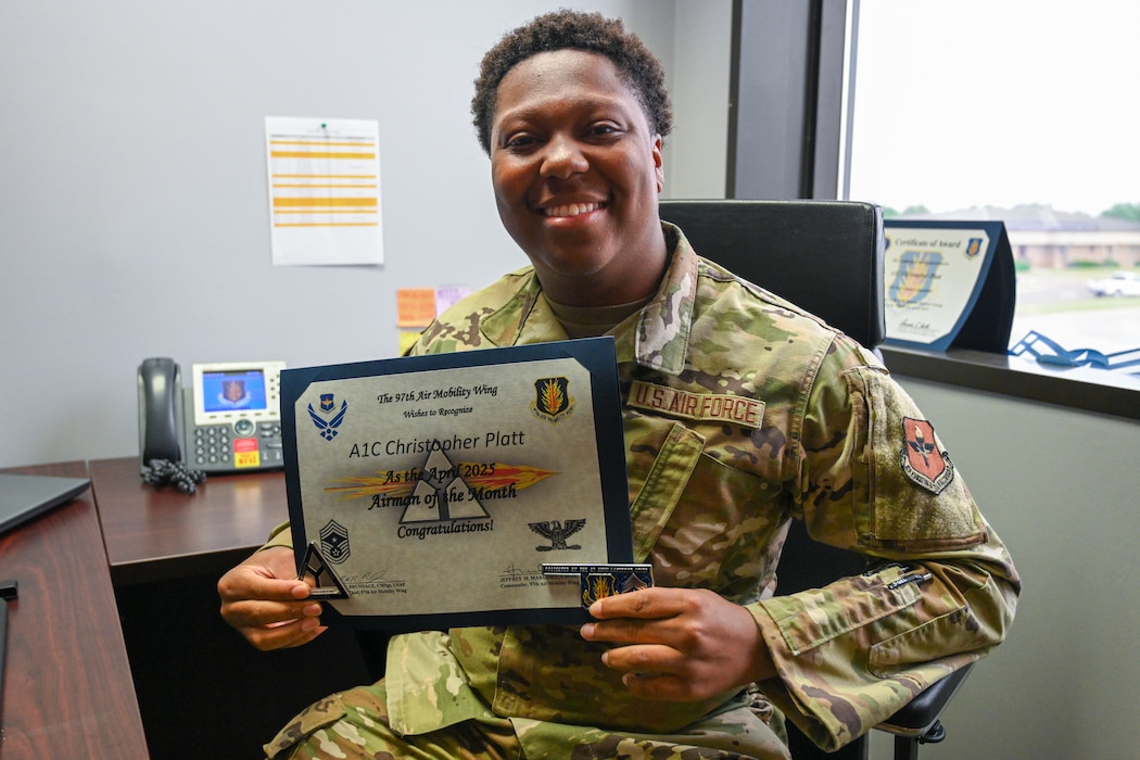 U.S. Air Force Airman 1st Class Christopher Platt, 97th Force Support Squadron (FSS) force management technician, holds his award and two coins at Altus Air Force Base, Oklahoma, May 29, 2025. Platt has been with the 97th FSS for almost one year and was recently promoted to Airman 1st Class. (U.S. Air Force photo by Airman 1st Class Nathan Langston)