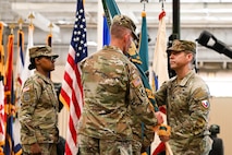 U.S. Army Lt. Col. Stuart Williams, outgoing Army Field Support Battalion-Charleston commander, passes the flag to Col. Jeremiah O’Conner, 404th Army Field Support Brigade commander, during the AFSBn-CHS change of command ceremony at Joint Base Charleston.
