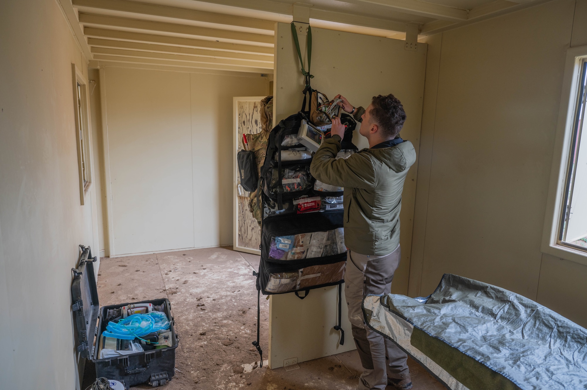 A special operations forces medical element team member sets up a vital sign monitor at a standup field clinic