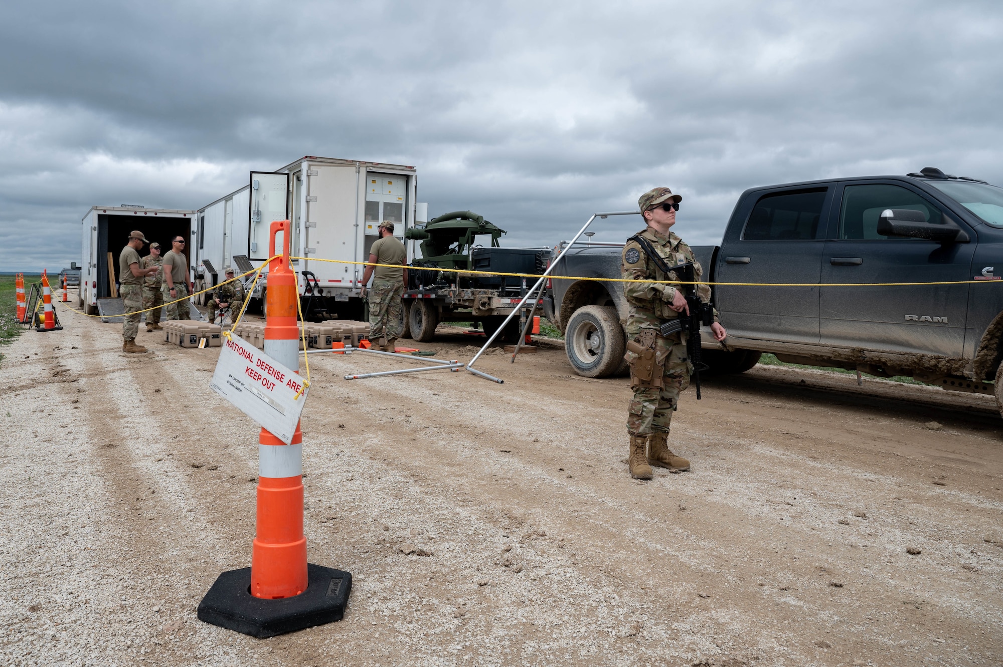 A Guardian stands guard as team members set up a mobile constellation control station.