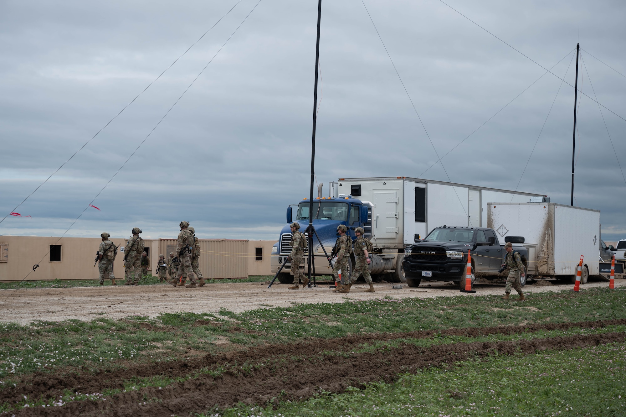 Image of security forces members walking around vehicles and securing an area during an exercise.