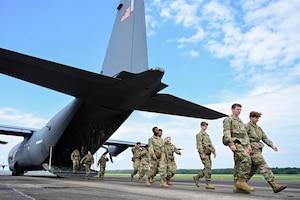A group of people walk out of a plane.