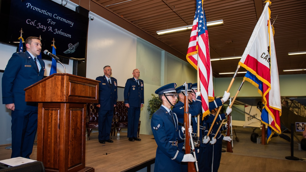 The national anthem being sung as the honor guard present the colors