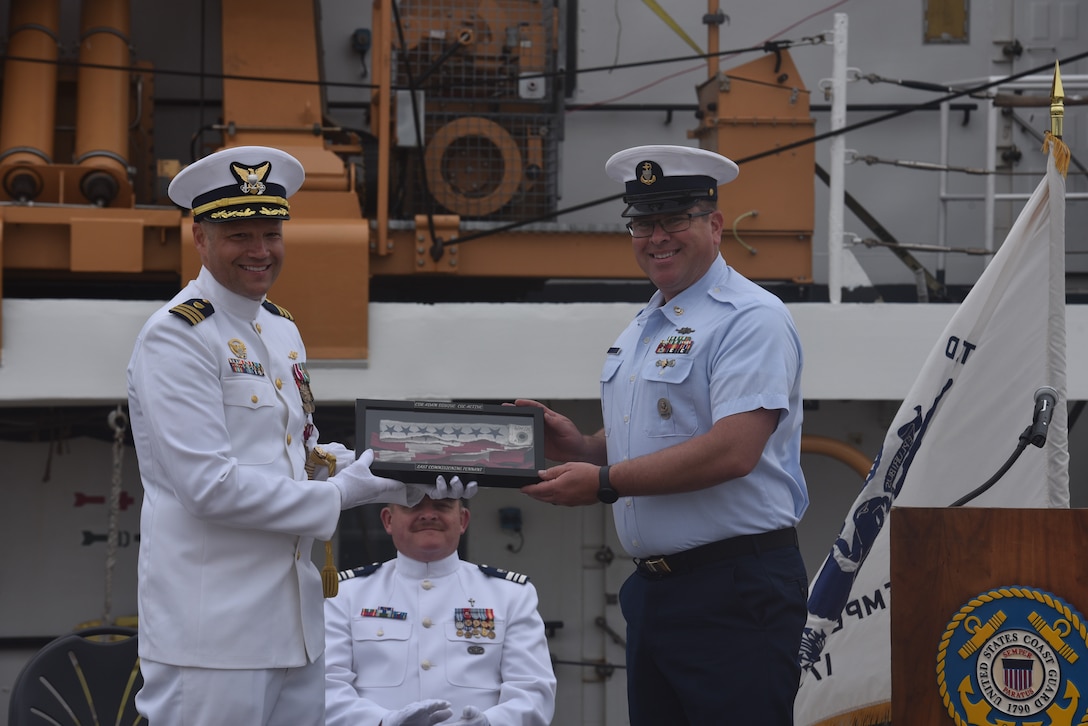 A member of the crew presented the ship's pennant to Cmdr. Adam Disque, Sunday, Jun. 8, in San Diego during the change of command ceremony for U.S. Coast Guard Cutter Active (WMEC 618). Disque served as Active’s commanding officer from June 2023 to June 2025. Under Disque’s leadership, Active deployed to the Eastern Pacific Ocean in support of counternarcotics efforts, search and rescue and territorial integrity. (U.S. Coast Guard photo by Lt. Karen Hovey)