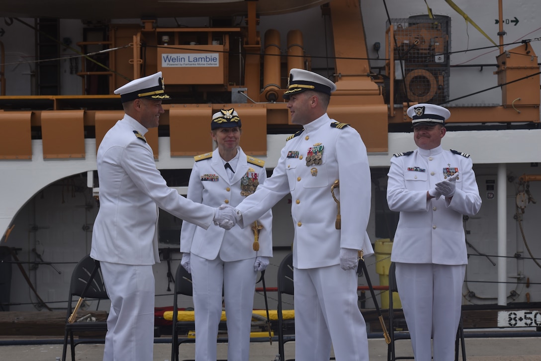 During the change of command ceremony for U.S. Coast Guard Cutter Active (WMEC 618), Cmdr. Earl Potter and Cmdr. Adam Disque shook hands, Sunday, Jun. 8, in San Diego. Rear Adm. Joanna Hiigel, deputy commander of Coast Guard Pacific Area, presided over the ceremony.  Under Disque’s leadership, Active deployed to the Eastern Pacific Ocean in support of counternarcotics efforts, search and rescue and territorial integrity. (U.S. Coast Guard photo by Lt. Karen Hovey)