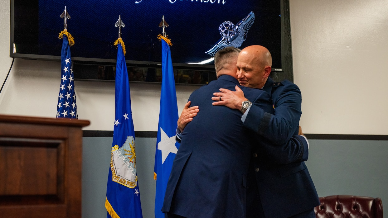 Friends hug during a promotion ceremony