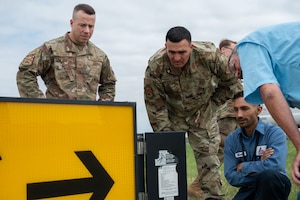 Members of the 7th Civil Engineer Squadron discuss electrical components of airfield lights during a knowledge exchange at the Abilene Regional Airport, June 6, 2025.  This partnership strengthens the 7th CES electrical team's ability to maintain safe and reliable airfield operations. (U.S. Air Force photo by Senior Airman Alondra Cristobal Hernandez)