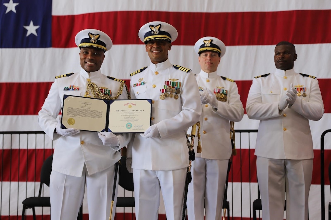 Capt. Willie L. Carmichael, Seventh Coast Guard District chief of staff (left) presents Capt. Lawrence Gaillard (right), outgoing Air Station Borinquen commanding officer, with the Coast Guard Meritorious Service Medal (Gold Star in Lieu of a Third) during the unit’s change of command ceremony in Aguadilla, Puerto Rico June 11, 2025.  Capt. Jeffrey P. Owens relieved Gaillard as Air Station Borinquen’s commanding officer. (U.S. Coast Guard photo courtesy of Coast Guard Auxiliarist Oscar Salinas)