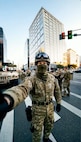 AI-generated man wearing a camoflage uniform appearing to hold a phone offscreen.