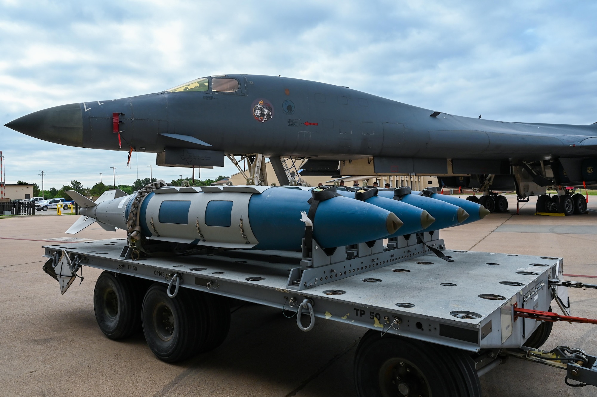 Static displays of GB-38 Joint Direct Attack Munitions and a B-1B Lancer, assigned to the 28th Bomb Squadron, sit on the flightline for observation during the B-1 Reunion at Dyess Air Force Base, Texas, June 6, 2025.The multi-mission B-1, carrying the largest conventional payload of both guided and unguided weapons in the Air Force, is the backbone of America's long-range bomber force, rapidly delivering massive quantities of precision and non-precision weapons against any adversary, anywhere in the world, on demand. June 2025 marks the 40th anniversary of B-1B Lancer at Dyess AFB.  (U.S. Air Force photo by Airman 1st Class Adrien Tran)