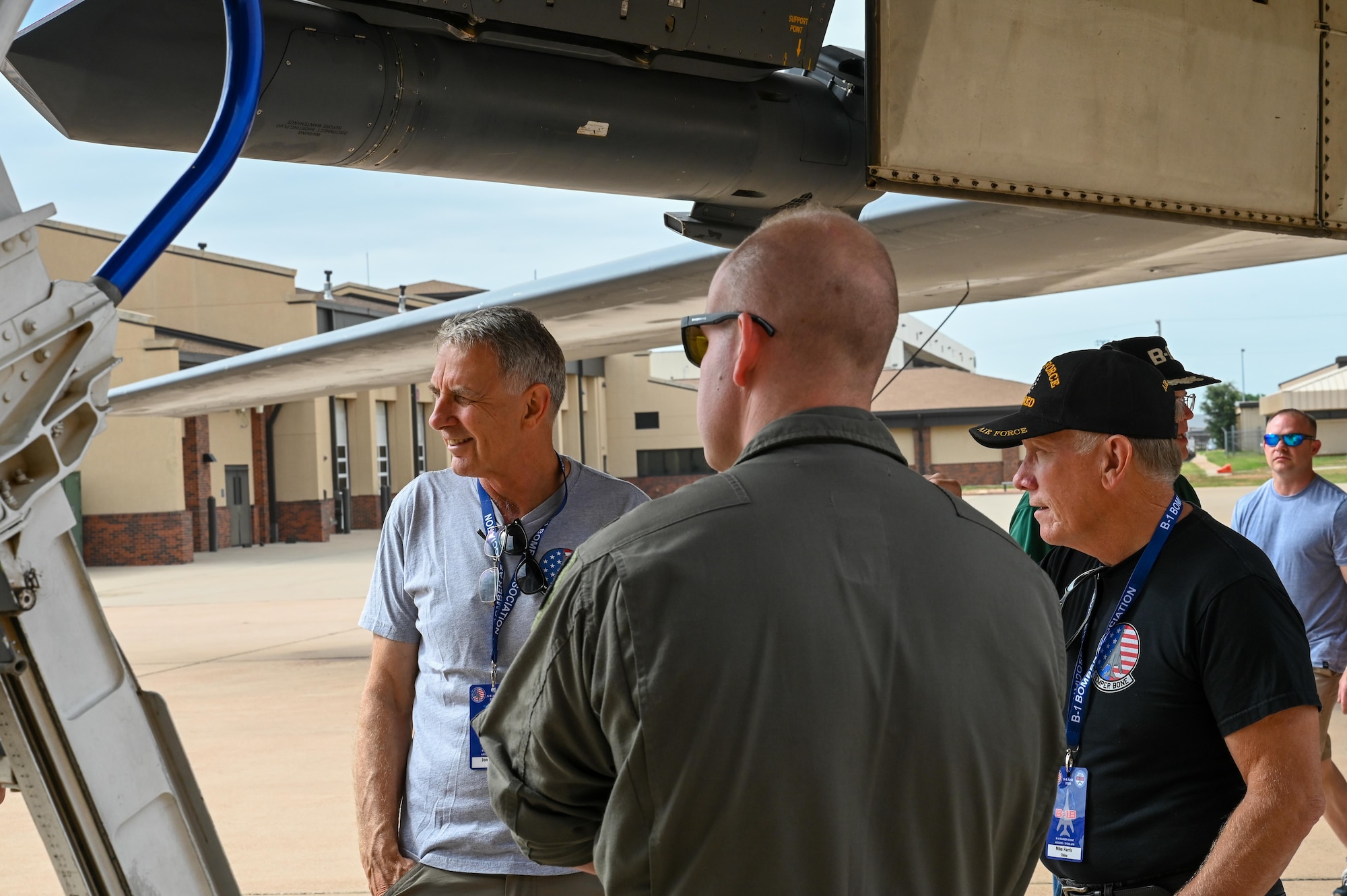 Retired and active-duty U.S. Air Force personnel interact under a B-1B Lancer static display during the B-1 Reunion at Dyess Air Force Base, Texas, June 6, 2025. June 2025 marks the 40th anniversary of B-1B Lancer at Dyess AFB. (U.S. Air Force photo by Airman 1st Class Adrien Tran)