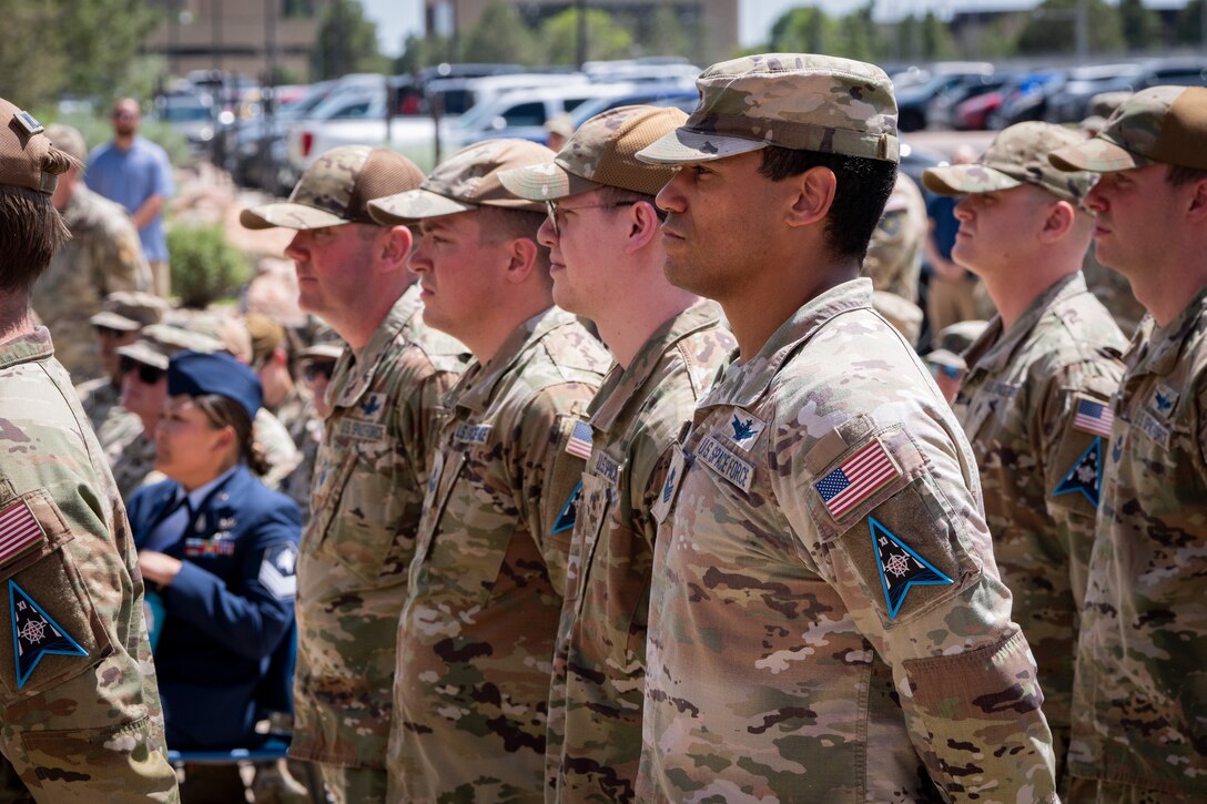 Change of command ceremony with flags and uniformed personnel.