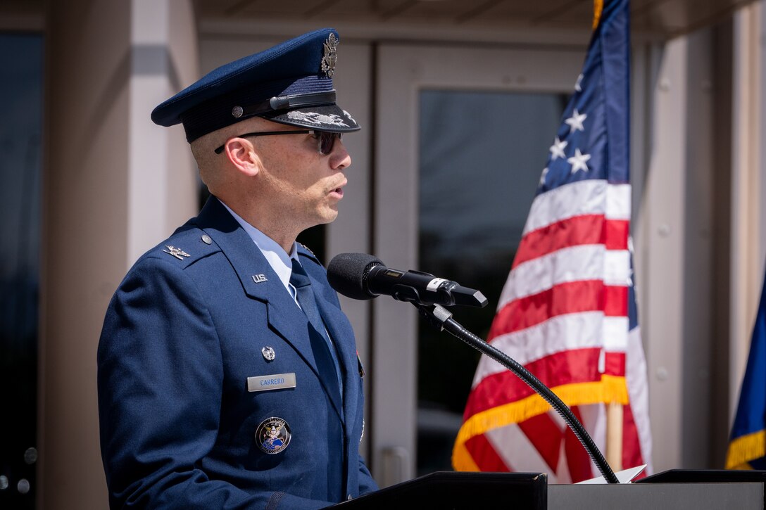 Change of command ceremony with flags and uniformed personnel.
